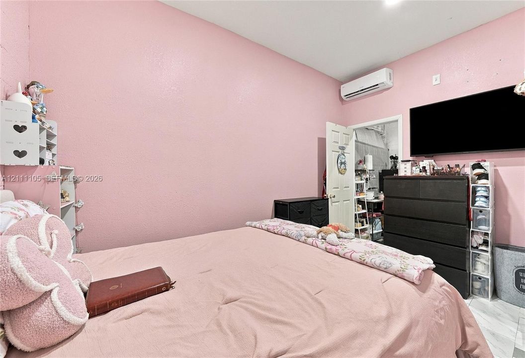 Wall-mounted ductless air conditioning unit and white six-panel interior door