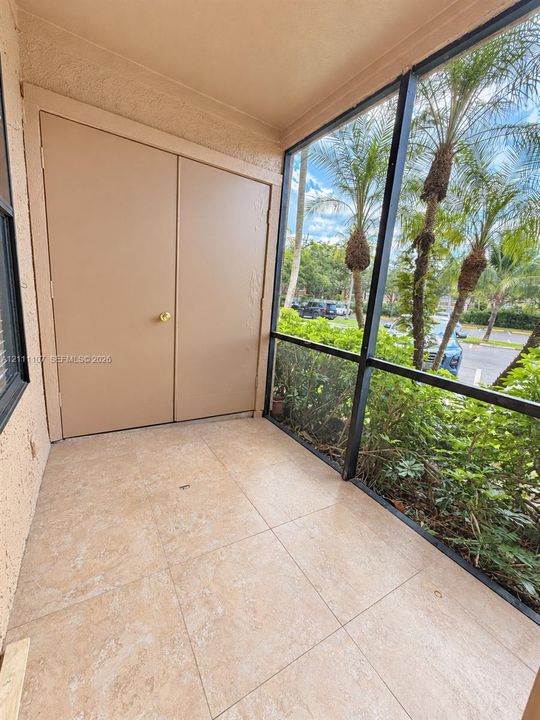 Screened-in enclosure with large-format tile flooring and double-door storage closet