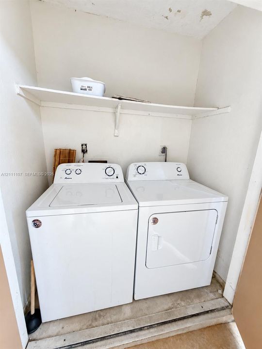 Laundry closet featuring overhead shelving and white appliance hookups