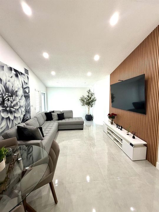 Vertical wood-slat accent wall, polished tile flooring, and recessed ceiling lighting