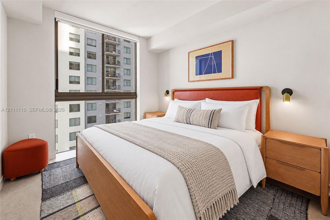 Floor-to-ceiling windows with dark metal framing and wall-mounted metallic sconces