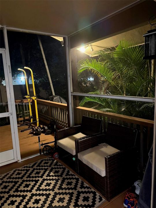 Screened-in porch featuring wood-tone decking and a perimeter railing