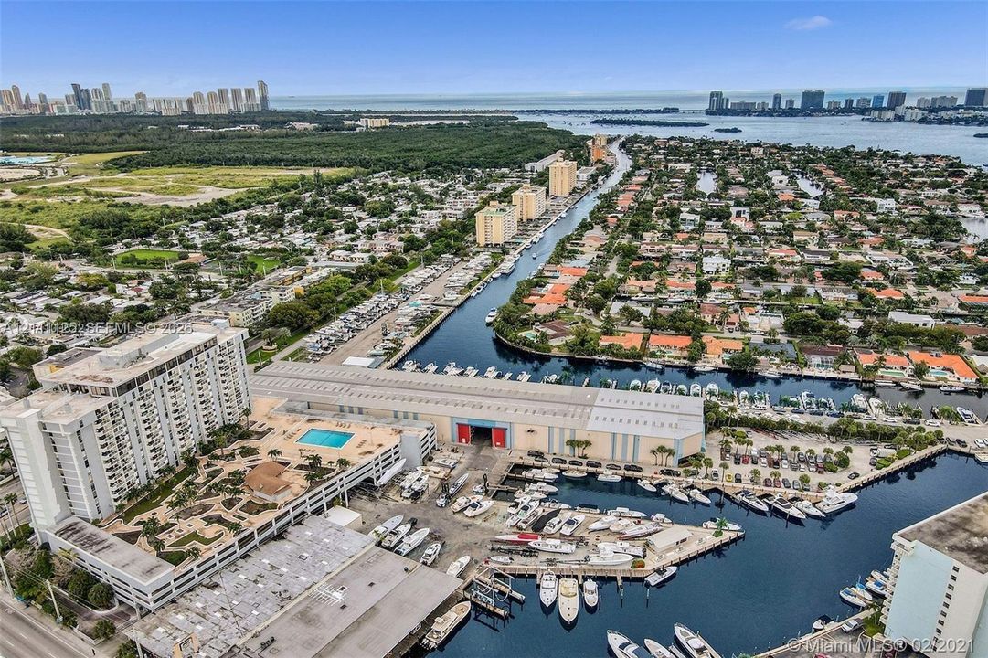 Aerial perspective showcasing waterfront access, a dedicated deep-water marina, and a multi-level surface parking structure