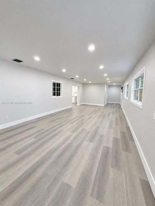 Open interior space featuring wood-finish flooring, recessed lighting, and multi-pane windows with crisp white trim