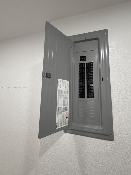 Flush-mounted electrical service panel featuring a metal enclosure, hinged door, and multiple circuit breakers