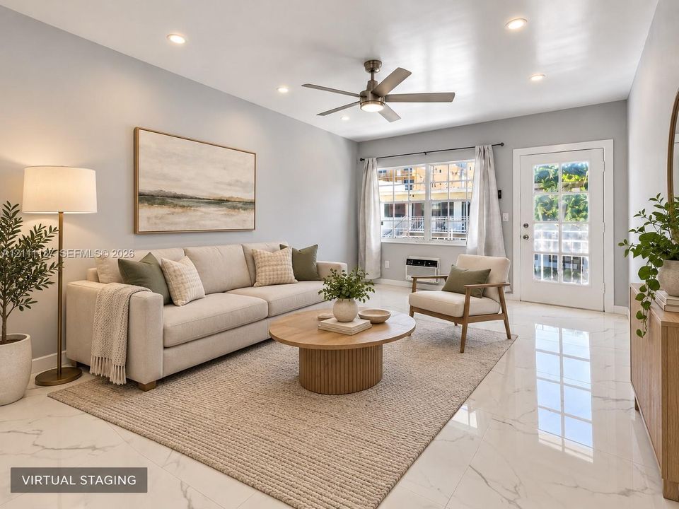 Neutral-toned interior featuring polished stone-finish flooring, recessed lighting, a brushed-nickel ceiling fan, and a glass-paneled exterior door