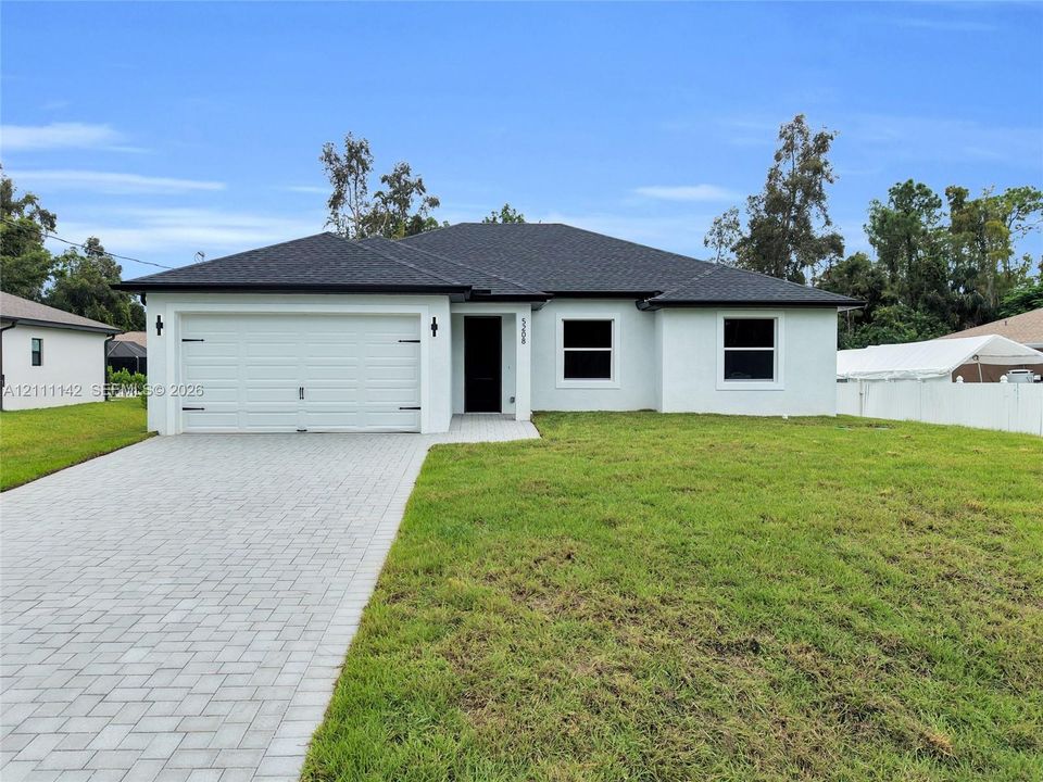 Front view of the paved driveway leading to the 2-car garage and front entry.