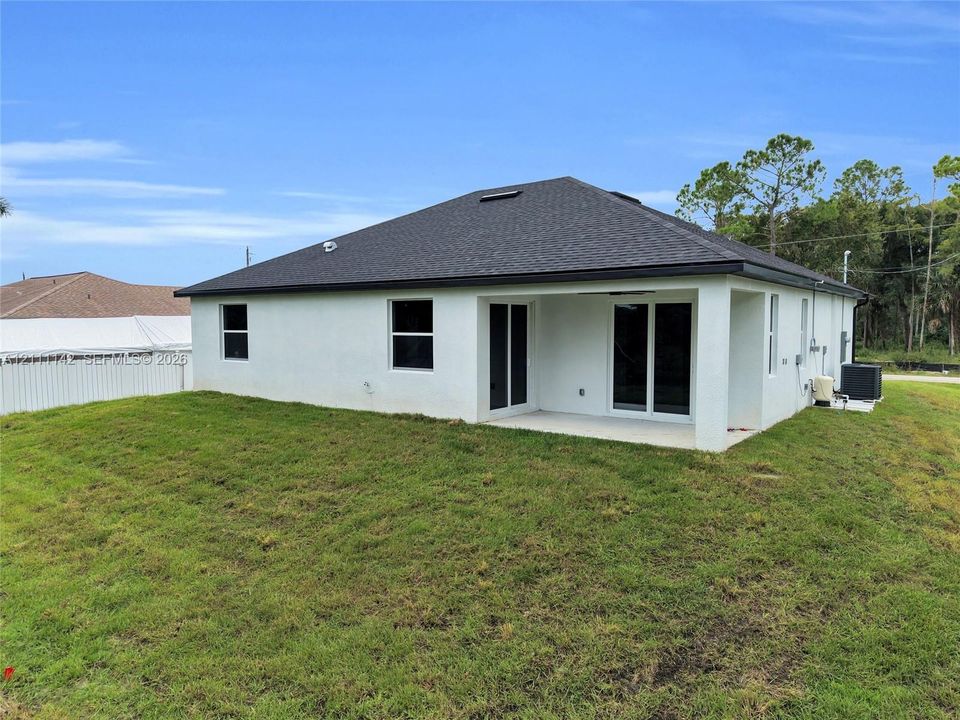 Rear exterior with lanai and sliding glass doors.