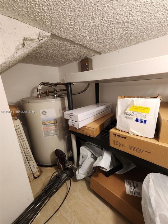 Utility area featuring a water heater and structural ceiling finish
