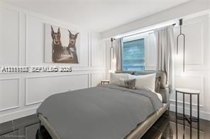 Room featuring wall molding details, high-gloss floor tile, and dual pendant lighting fixtures