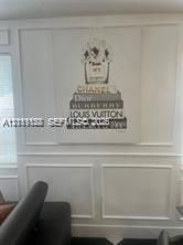Wall featuring custom white wainscoting and applied panel molding