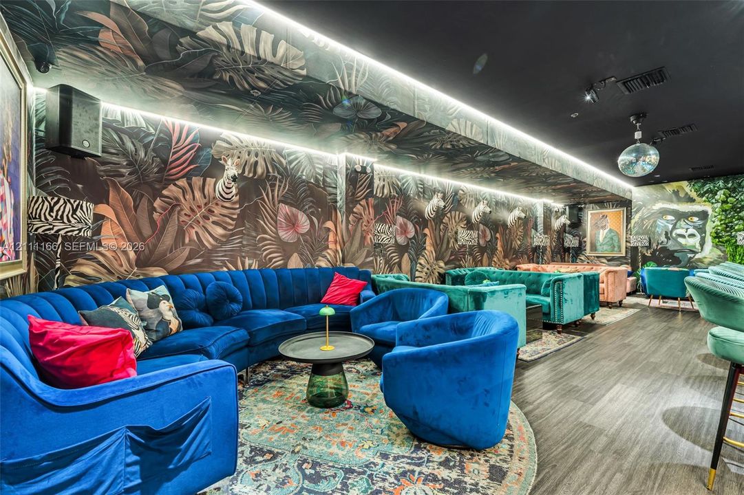 Botanical-patterned wallpaper, recessed linear LED accent lighting, dark-toned wood-finish flooring, and a mirrored ceiling fixture