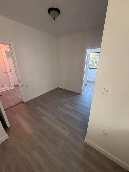 Interior space featuring wood-finish flooring, neutral wall paint, and a dome-style ceiling light fixture