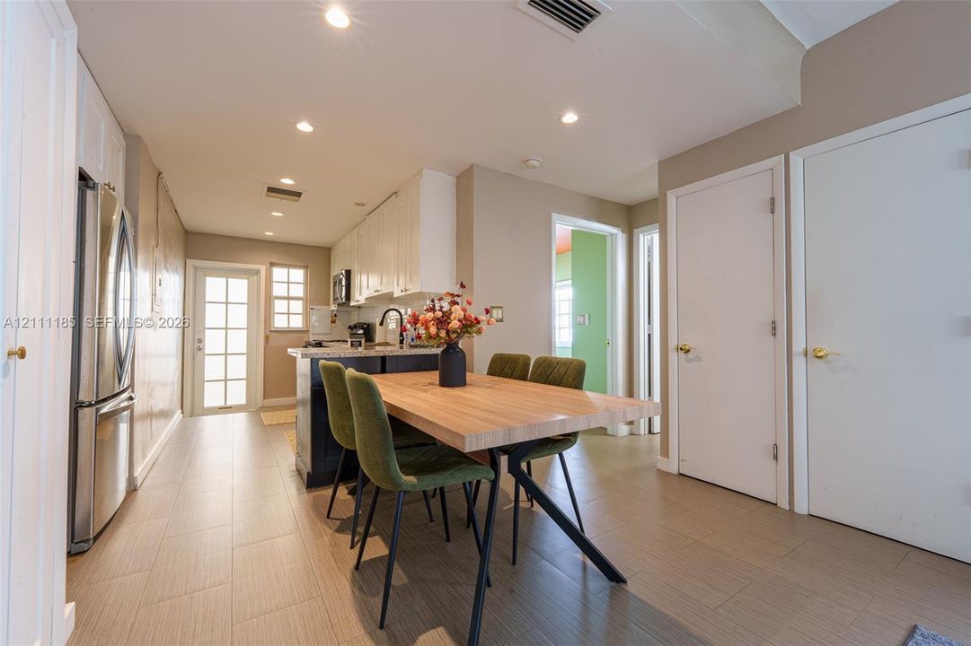Kitchen featuring white cabinetry, stainless steel refrigerator, recessed lighting, and tile flooring throughout