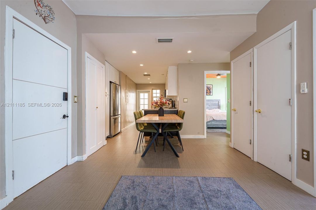 Neutral-toned interior featuring recessed lighting, tile flooring, and multiple solid-core interior doors with metallic hardware