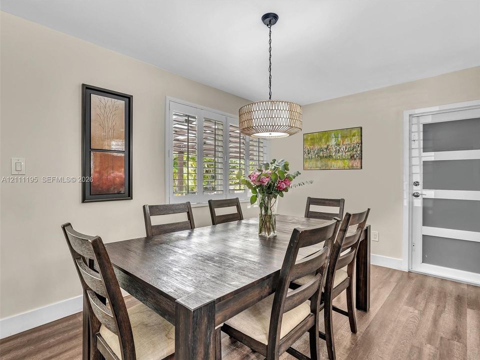 Wood-finish flooring, plantation shutters, drum pendant lighting, and a frosted glass-paneled door