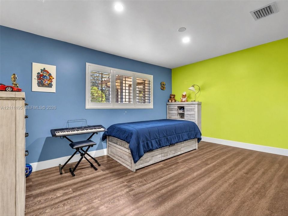 Wood-finish flooring, multi-pane window with interior shutters, and recessed ceiling lighting