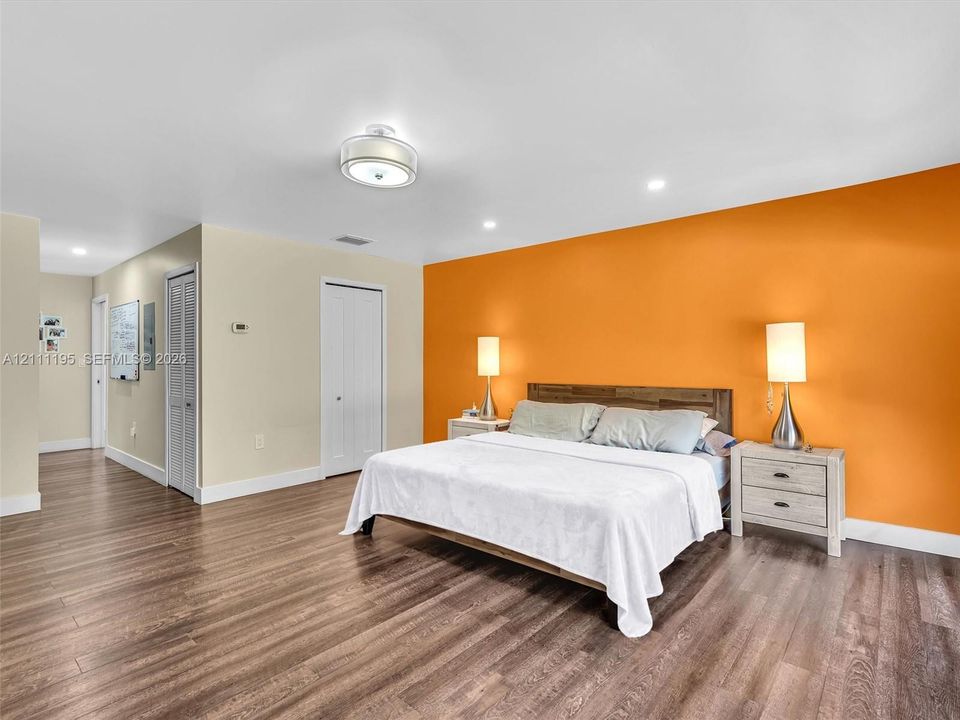Wood-finish flooring, recessed lighting, flush-mount ceiling fixture, and dual-panel closet doors