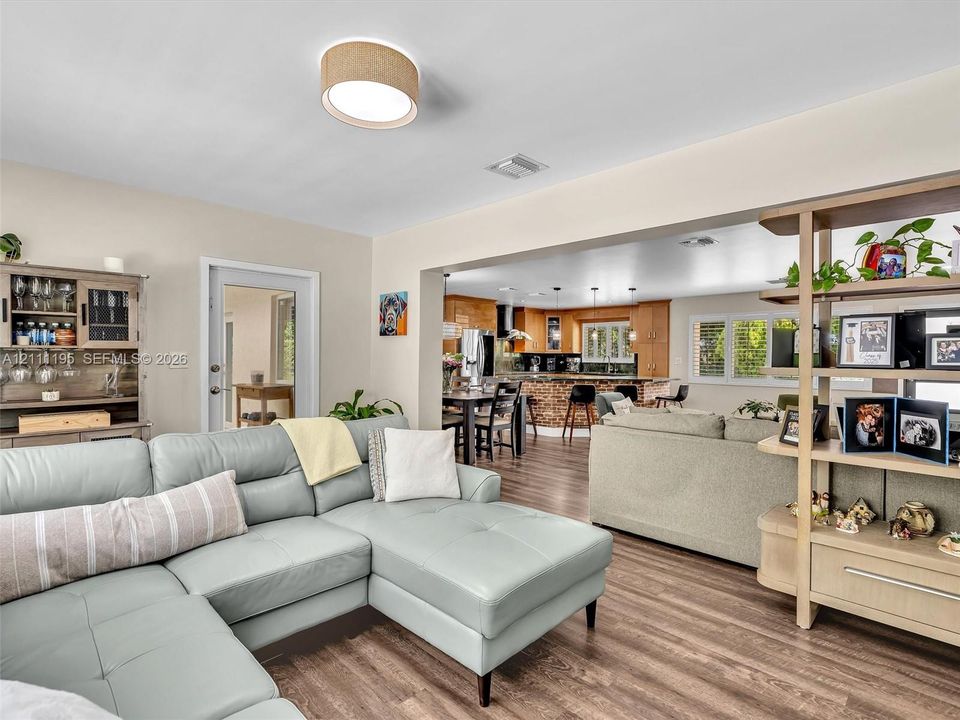 Open-concept space featuring wood-finish flooring, a drum-style flush mount ceiling light, and custom built-in cabinetry
