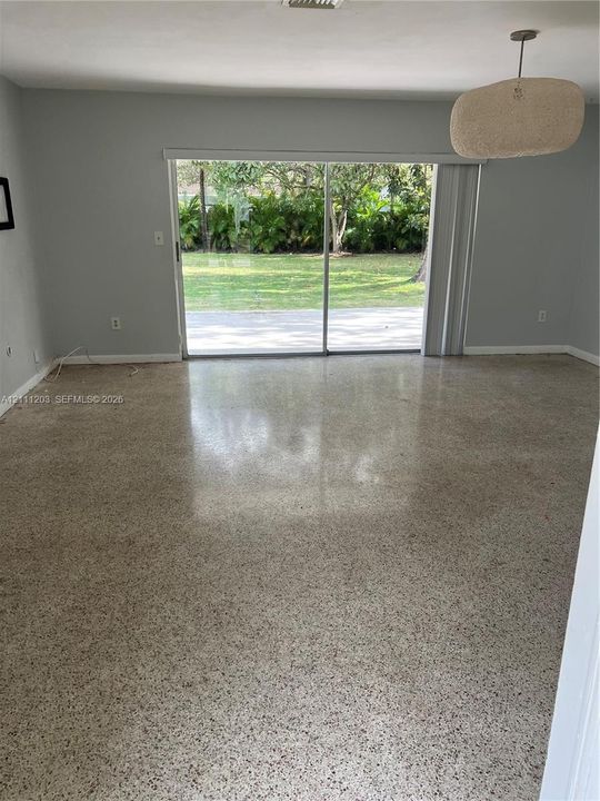 Polished terrazzo flooring, sliding glass door, and neutral wall tones