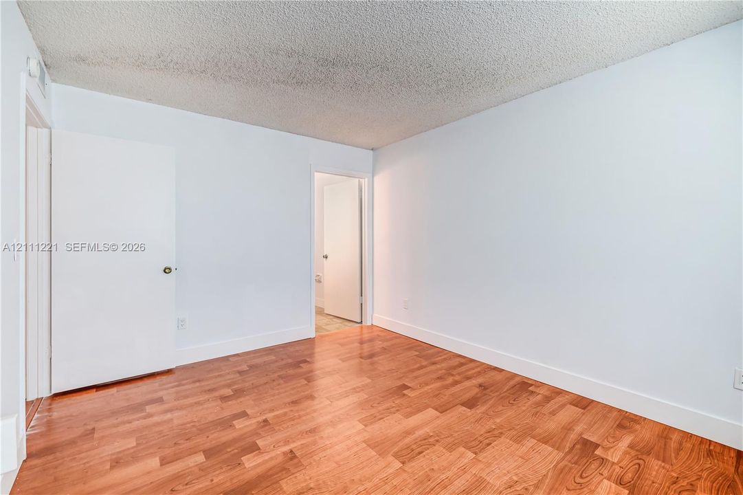 Room featuring wood-finish flooring and two solid-core interior doors