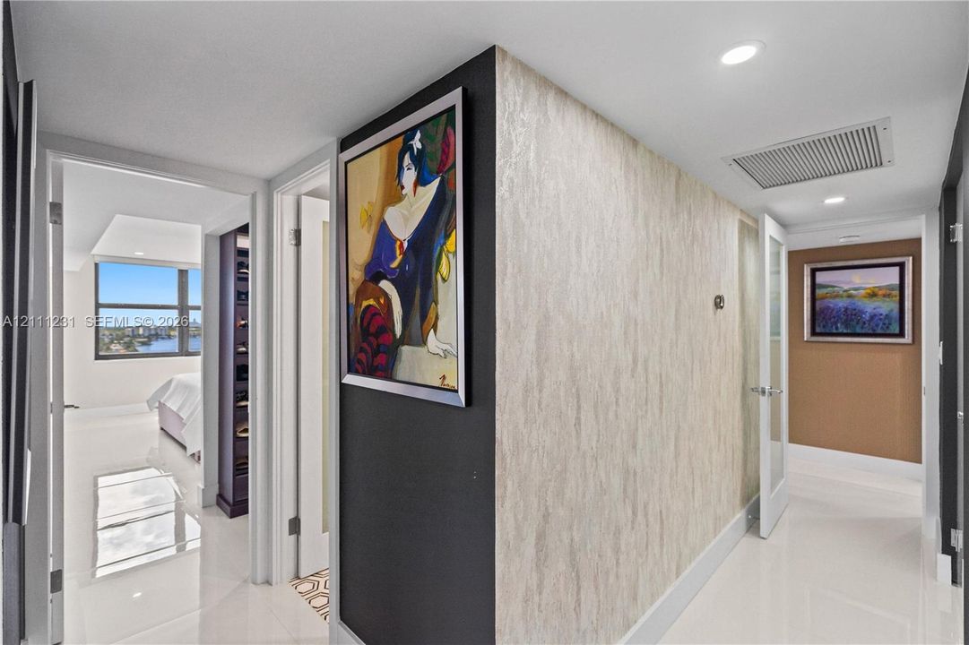 Hallway featuring polished tile flooring, recessed lighting, and a textured accent wall