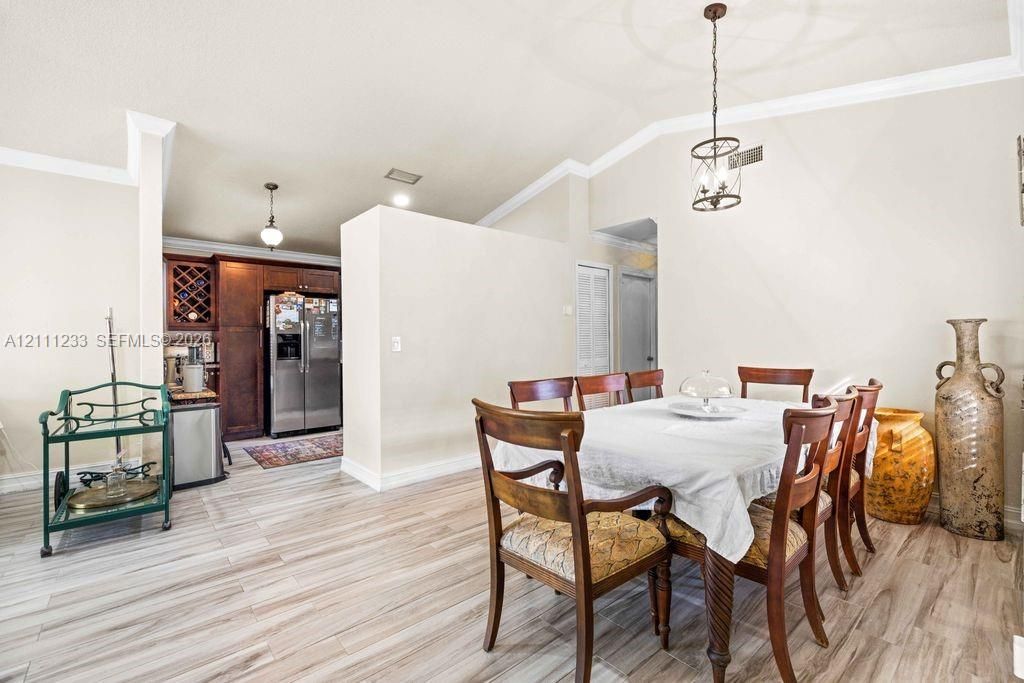 Vaulted ceilings, wood-finish flooring, custom built-in wine storage, and decorative pendant lighting