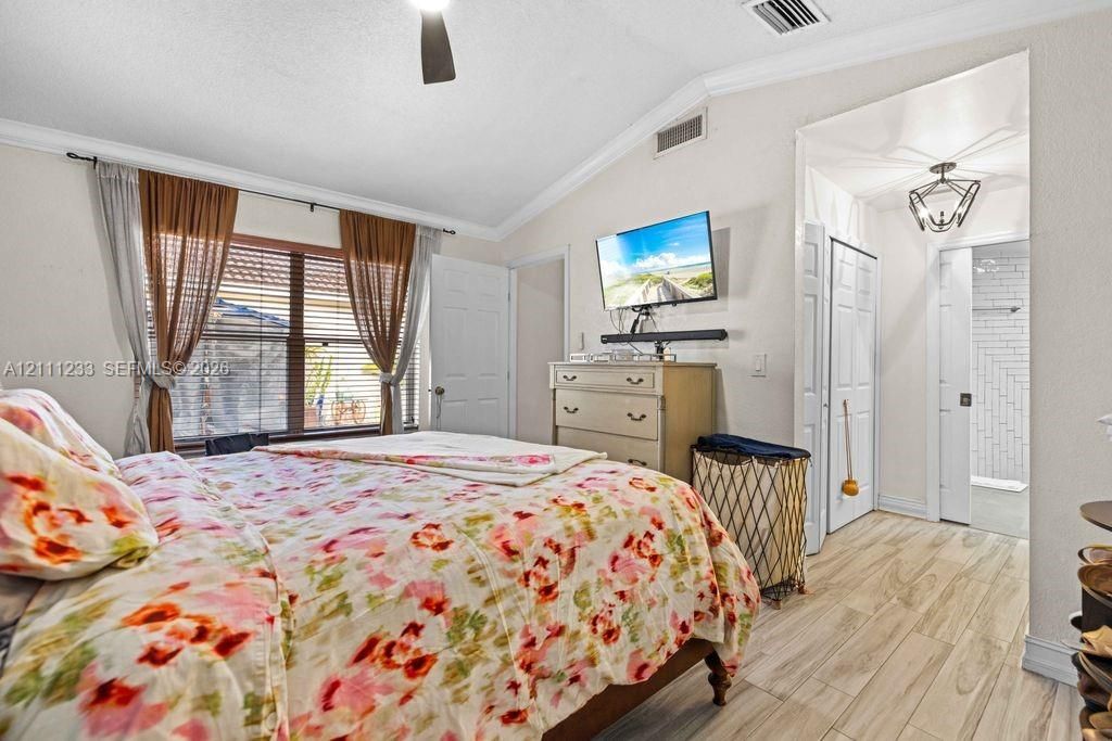 Vaulted ceilings, wood-finish flooring, recessed lighting, and a sliding barn door entry