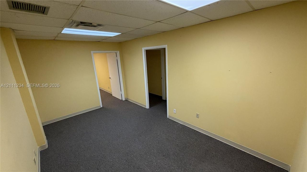Interior space featuring a drop ceiling with recessed lighting and carpeted flooring