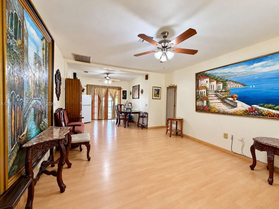 Open-concept living space featuring wood-finish flooring and dual ceiling fans with integrated light fixtures