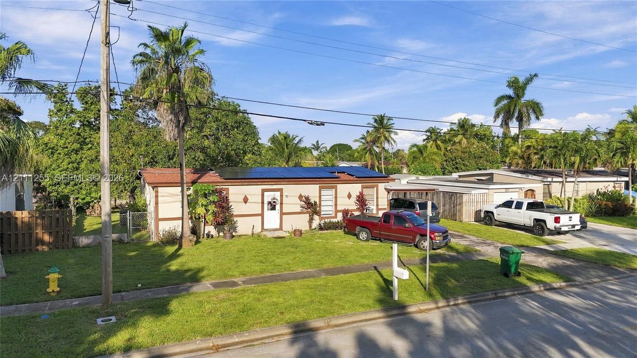 Single-story residence featuring a low-slope roof, installed solar panels, and a concrete driveway