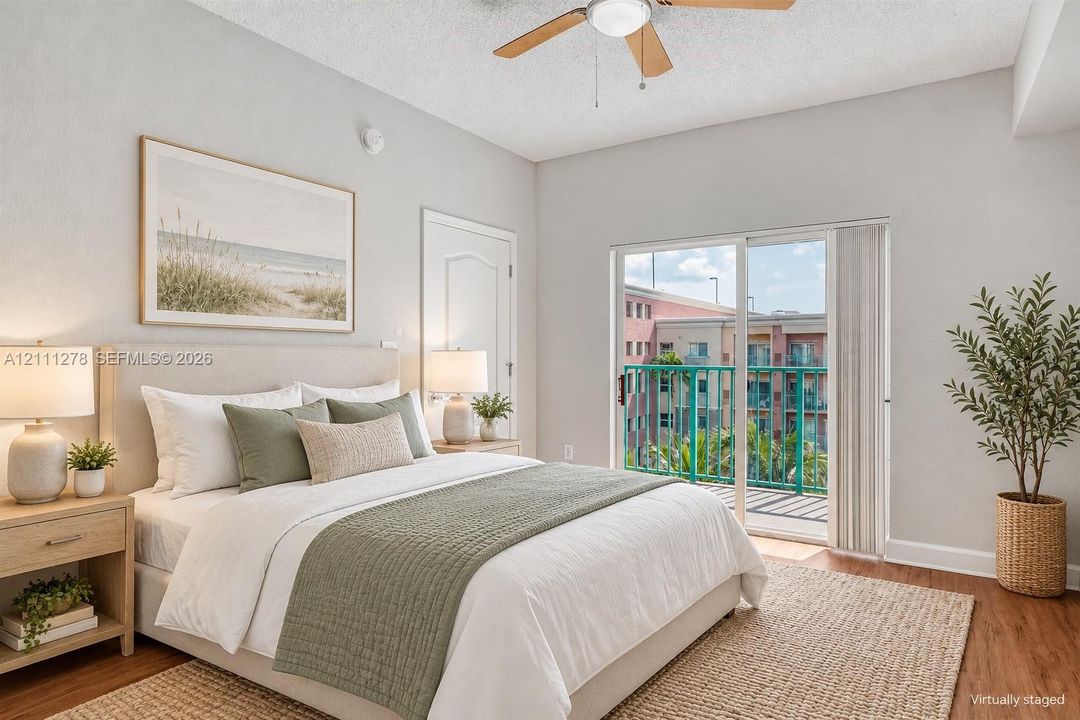 Bedroom featuring wood-finish flooring, a ceiling fan with light fixture, and a sliding glass door providing access to a balcony