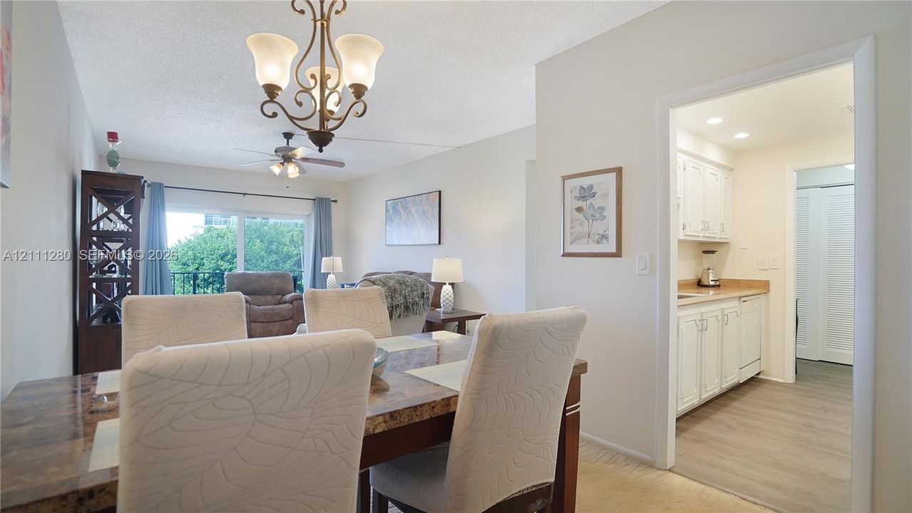 Dining area featuring a classic iron chandelier, wood-finish flooring, and sliding glass doors
