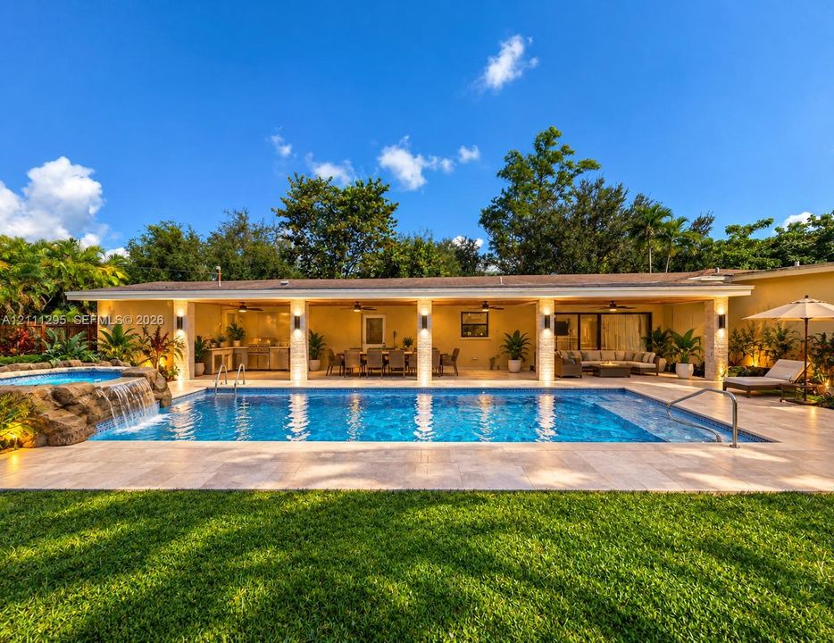 Conceptual rendering - Rear exterior featuring a covered patio with recessed lighting, in-ground swimming pool, stone-finish spa with waterfall feature, and stone-tiled pool deck