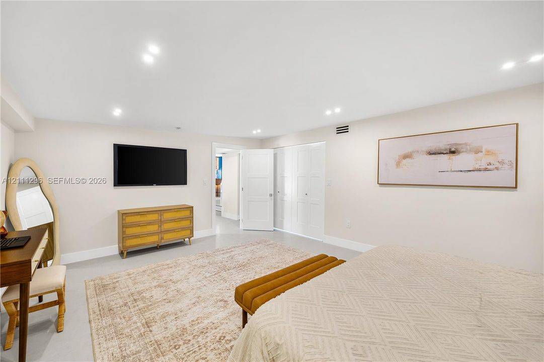 Neutral-toned walls, recessed lighting, and closet doors with recessed panels