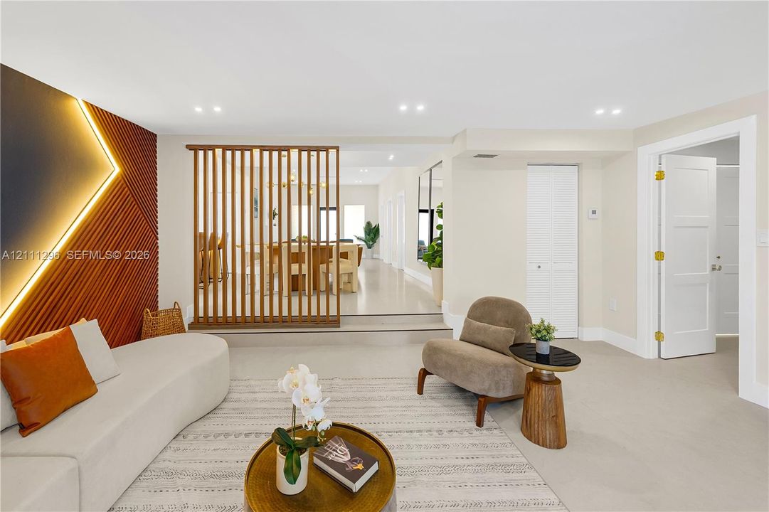 Living area featuring a vertical-slat wood room divider, textured accent wall with recessed lighting, smooth-finish flooring, and recessed ceiling lights