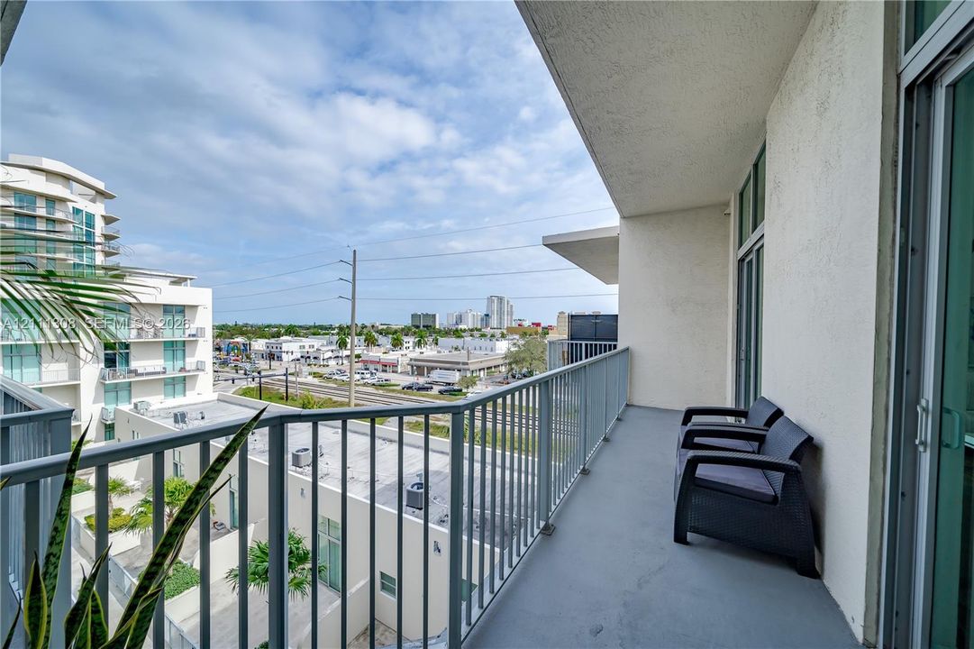 Covered balcony featuring concrete flooring and a vertical metal railing