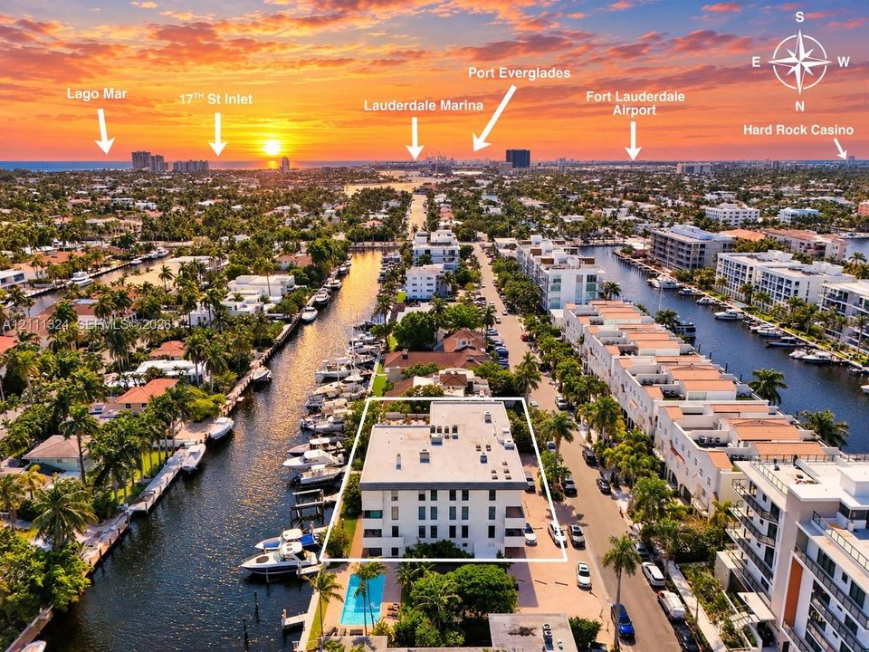 Aerial perspective featuring(facing South) multi-story residential building, private swimming pool, deep-water canal access, and mature landscaping