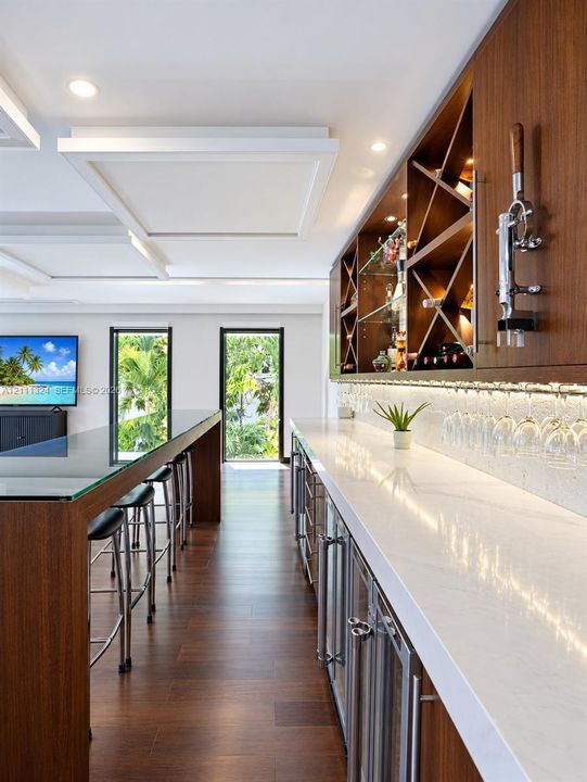 Custom built-in bar featuring wood cabinetry, stone countertops, integrated wine storage, glass-front beverage refrigeration, and wood-finish flooring