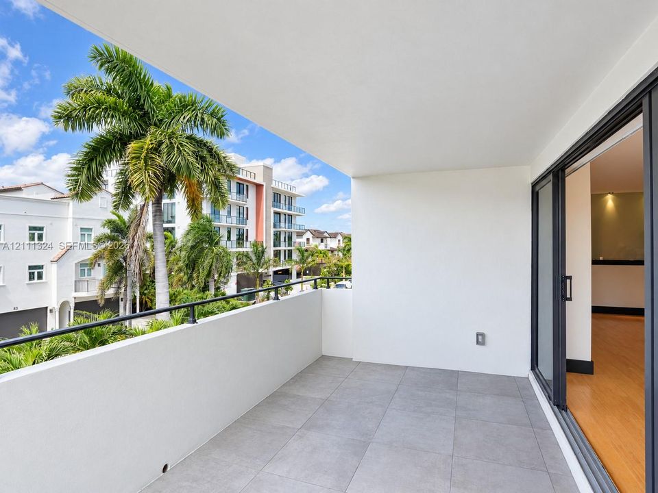 SW-Covered balcony featuring oversized gray tile flooring, a metal railing, and sliding glass door access