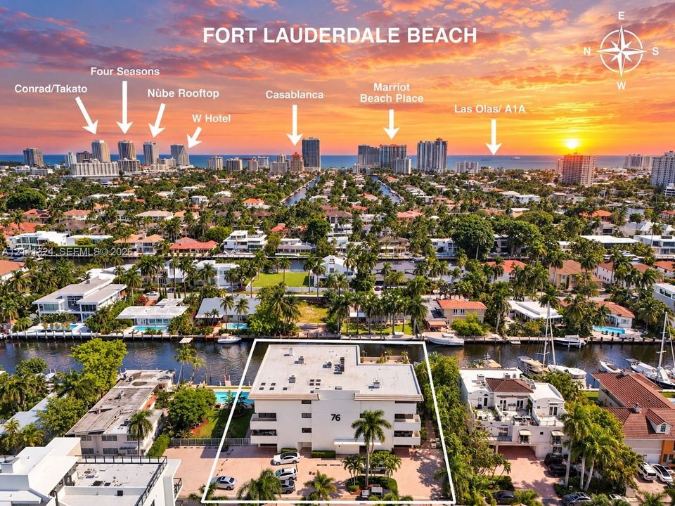 Aerial perspective(facing East) of property featuring deep-water canal frontage, paved surface parking, and mature palm trees