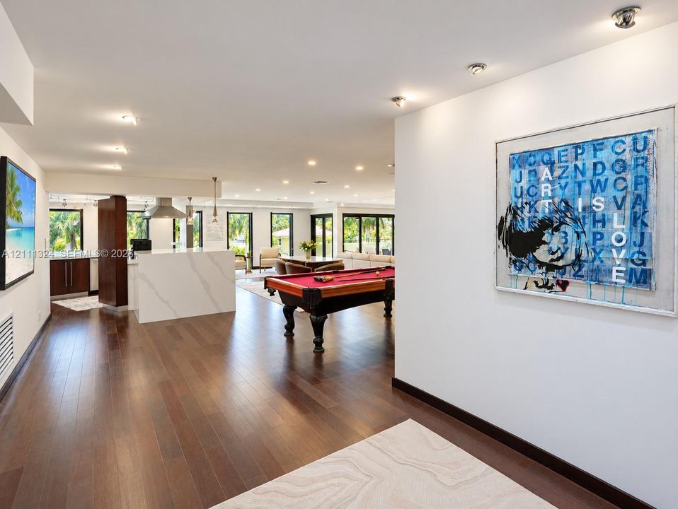 Entrance to Open-concept space featuring wood-finish flooring, recessed lighting, and a kitchen island with a stone-surfaced countertop