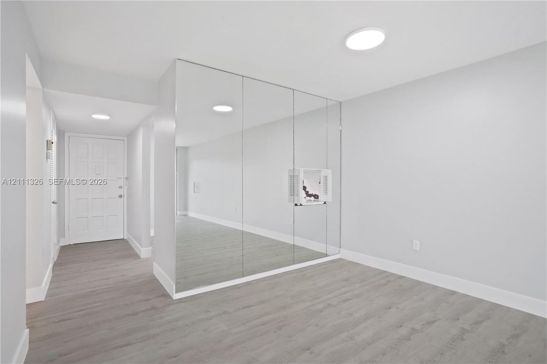 View of dining area from living room with entrance in the distance.