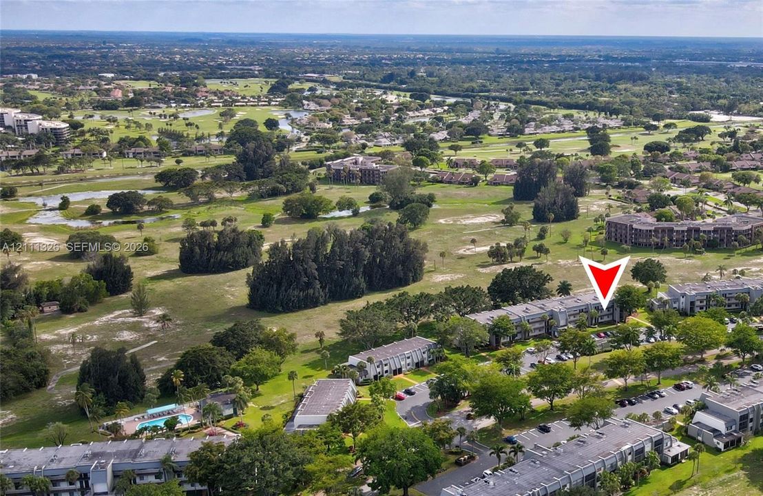 Aerial perspective of the community with a red arrow indicating the location of the unit.