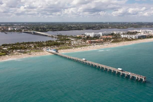 Aerial perspective of Lake Worth Beach expansive sandy coastline and pier.
