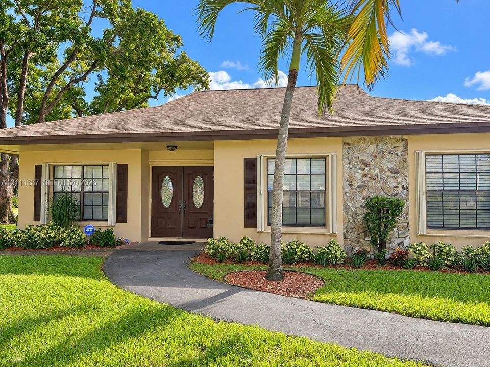 Single-story residence featuring a shingle roof, double-door entryway, exterior stone facade detailing, and shutter-framed windows