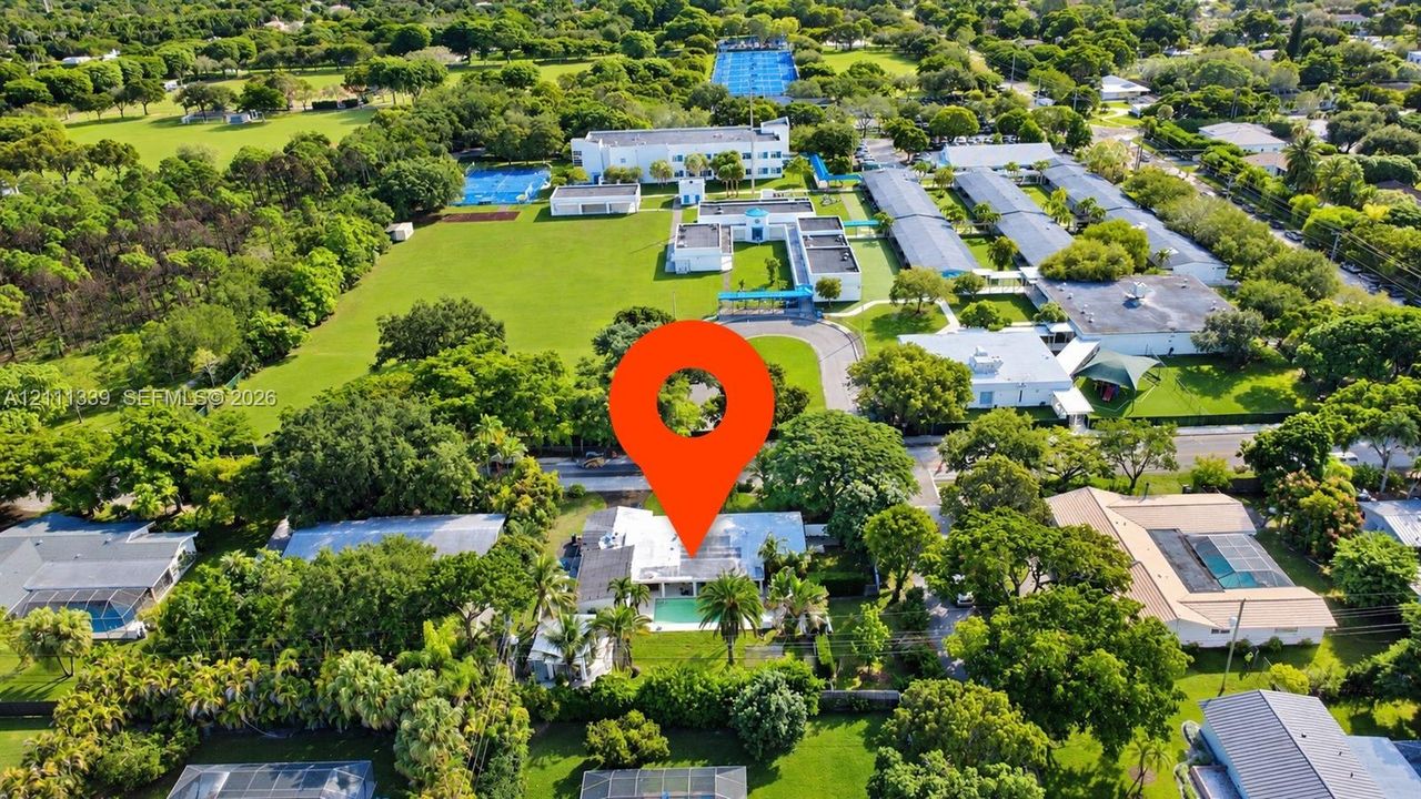 Aerial perspective of a property featuring an in-ground swimming pool and mature landscaping