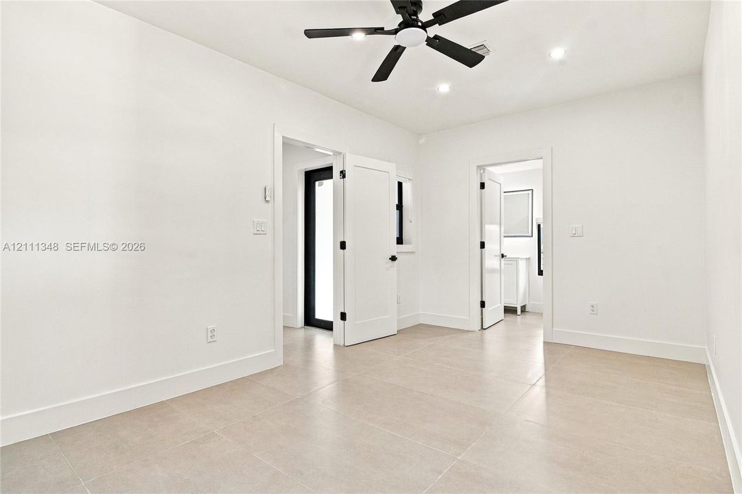 Neutral-toned ceramic tile flooring, matte black ceiling fan, recessed lighting, and shaker-style interior doors with matte black hardware