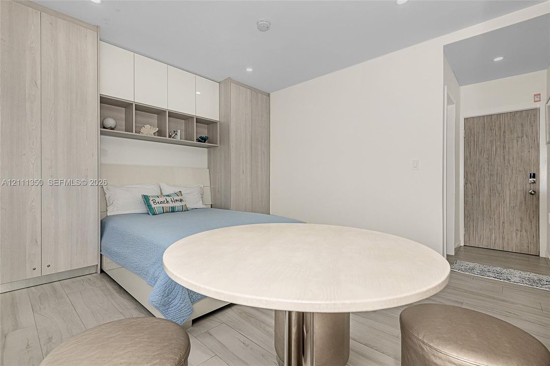 Built-in wood-finish cabinetry with overhead storage, recessed ceiling lighting, and light-toned wood-finish flooring