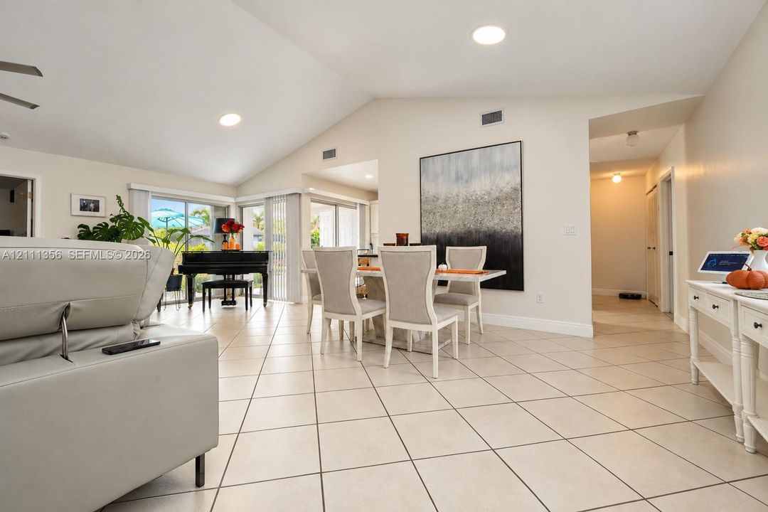 Vaulted ceilings, large-format tile flooring, recessed lighting, and multiple sliding glass door sets